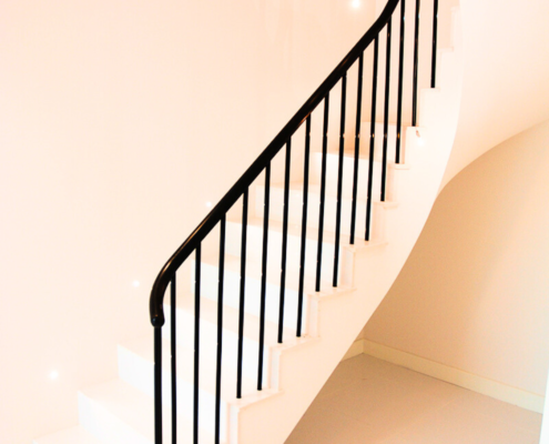 Clean and contemporary staircase featuring a sapele handrail and metal balusters