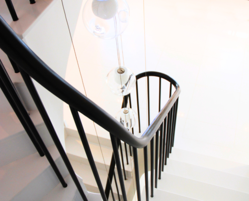 Modern staircase design with sapele handrail and metal balusters for a clean and sleek look.