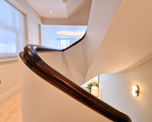 project, design, manufacture, installation, continuous Sapele handrails, solid wall balustrade, headquarters, luxury fit-out company, Finchatton, central London, complex profile, precision, attention to detail, 5-axis CNC machines, 3D scanner, French polished, stained dark, contrast, off-white plastered walls, sophistication, elegance, Director, Kenny Macfarlane, expertise, craftsmanship, high-quality, stunning handrail.