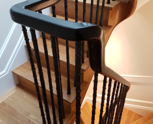 Favorite project Ash handrail Tight tolerance CNC machines Dramatic statement Stained and polished Jet-black finish 3 floors Cast iron spindles Survey Match steel core rail