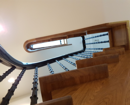 Favorite project Ash handrail Tight tolerance CNC machines Dramatic statement Stained and polished Jet-black finish 3 floors Cast iron spindles Survey Match steel core rail