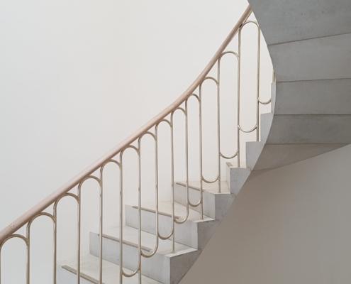 Cantilever stone stairs in art gallery, with brass balustrade and oak handrails