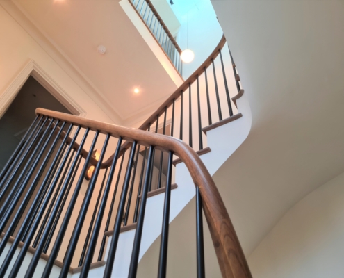 Elegant sweeping oak handrail Tapered steel spindles Unique contemporary staircase Six-storey luxury home Bespoke balustrade Steel spindles turned on a lathe Individual fixing of spindles No need for an ugly metal rail 3D model of the staircase Optimum precision French polished oak handrails Oak flooring Contractors: Bancroft Heath and Layzell Architects Continuous handrail Bespoke metal balustrade