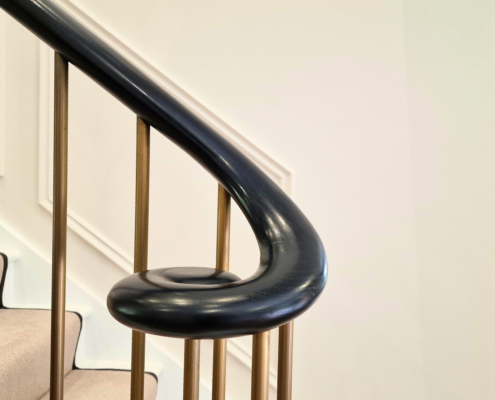 Luxurious staircases with bespoke brass and wooden handrails in Surrey homes.