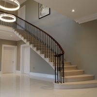 Sapele handrail French polished with Black steel spindles on Cantilever stone staircase to landing
