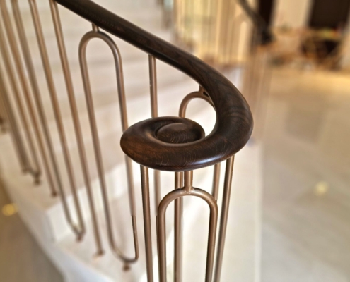 stunning curved balustrade double-stone-clad helical staircase bespoke steel shaped spindles bronze paint European Oak handrails 5 axis CNC machine French polished custom-made balustrade curved staircase North London