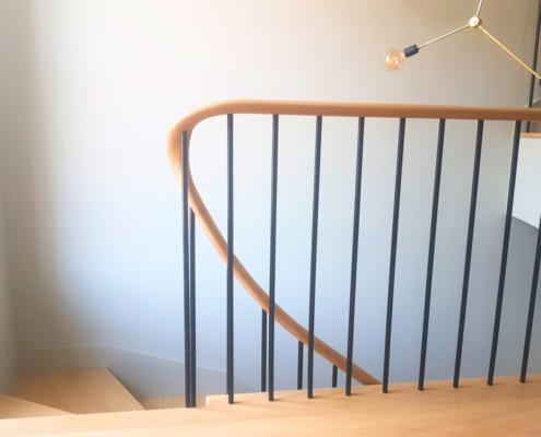 Excellent project Style European oak handrails Sleek and modern Black spindles Home in Chelsea Curved stringers No newel posts Continuous handrail Pre-drilled spindle holes Balustrade installation 16mm diameter spindles Powder coated Natural oak finish