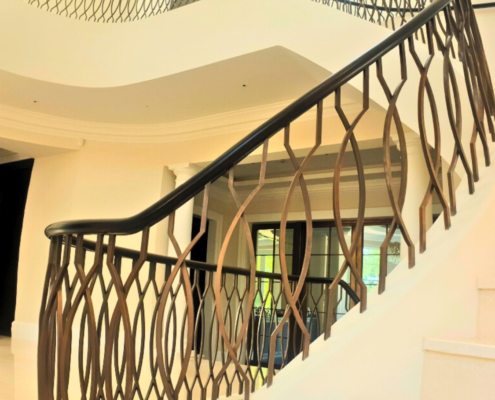 Statement staircase Residential projects Curved staircase Skilled fabricators Sweeping continuous handrails Steel core rail Bronzed balustrade Digital surveying 3D scanner American Ash hardwood handrails Factory production Pre-jointed Two-day installation French polished Internal doors Wall mounted handrails Seamless design