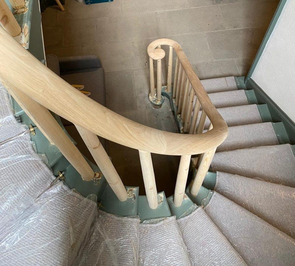 Oak monkey tail and rising curved handrail with wooden rounded spindles