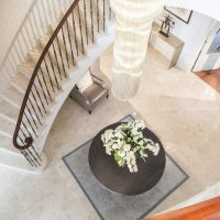 Curved stone staircase with Black Walnut handrail and steel balustrade