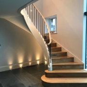 Bonfire Hall FSC-certified European Oak handrail steel spindles glass curved staircase Lake District private client design installation combination of materials unique striking design team fitting team survey move-in date