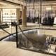 Timber profile Gloss Black handrail straight and helical sections on glass balustrade in retail store.