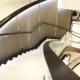 Timber profile Gloss Black handrail straight and helical sections on glass balustrade in retail store.