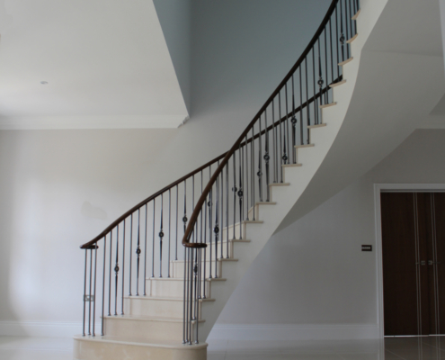 Stone clad stair Surrey Design team Stonemasons Steel spindles Black walnut handrails Core rail Steep pitch Precision drilling 16.5mm holes Perfect fit Handrail finish Lightfast stain French polished
