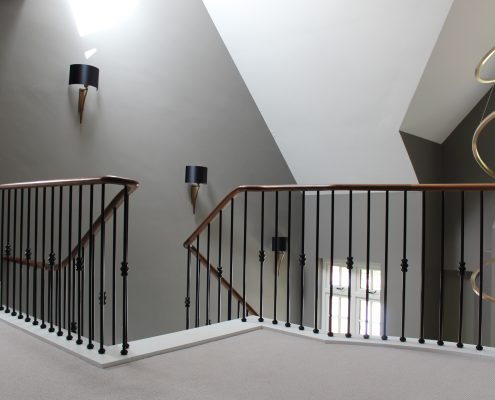 Contemporary staircase with bespoke Walnut handrail and steel balustrade to stairway and landing