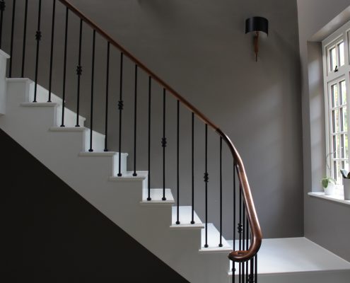 Stone staircase with Walnut handrails & Black steel balustrade