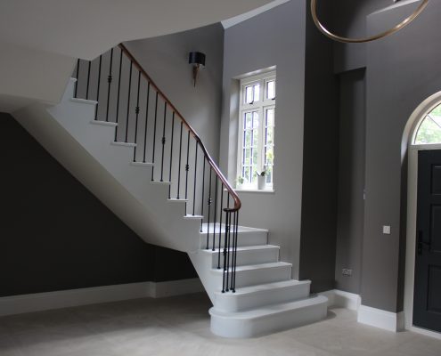 Stone staircase with Walnut handrails & Black steel balustrade