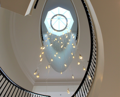 Curved staircase with matching coloured timber handrail & steel balustrade, drop down LED lights