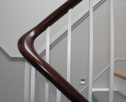 Sweeping Mahogany timber handrail with White square profile spindles to treads