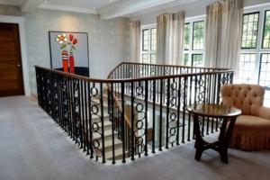 UK's leading stonemasons Artisan blacksmiths Magnificent centrepiece staircase Project in Sutton Coldfield Birmingham Black walnut handrails French-polished Matching surrounding furniture Customer satisfaction Sweeping staircases Expert team