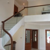 American black walnut handrail, sweeping into swan neck and landing on glass balustrade