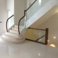 American Black Walnut handrail, sweeping into swan neck and landing on glass balustrade