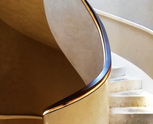 Helical handrail rising up spiralling staircase