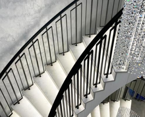 Treads with LED lights on curved stairway with balustrade