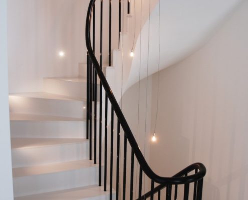 Sapele handrail with a French polished finish with steel rounded spindles on stone staircase