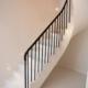 Stone curved staircase with Black timber handrail & Black steel rounded spindles