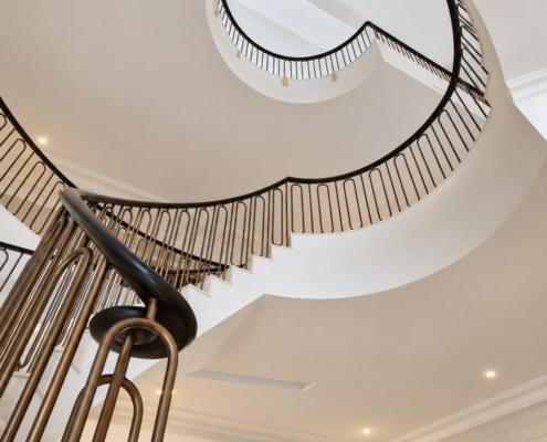 Helical staircase viewed from below with oak handrail scroll and lantern above