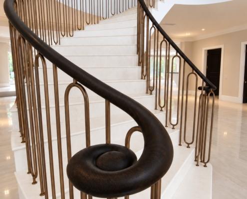 Hand finished oak handrail scroll with bronze hoop spindles at the foot of the stairs