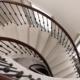 Stone spiral staircase with Black Walnut helical handrails and Black steel balustrade