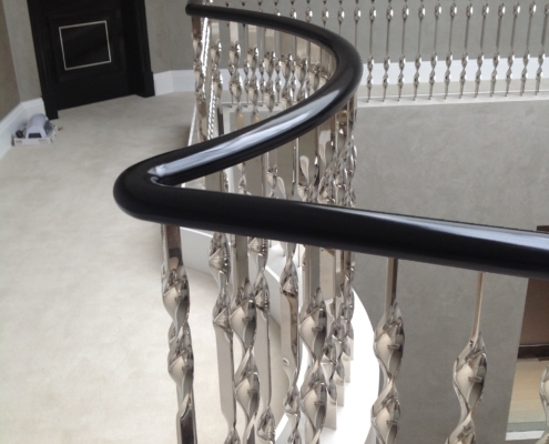 fantastic staircase centerpiece large house Wimbledon mirror finish stainless steel balustrade Archimet survey manufacture install ebonise wooden handrails sweeping black handrails walnut treads iconic stairs
